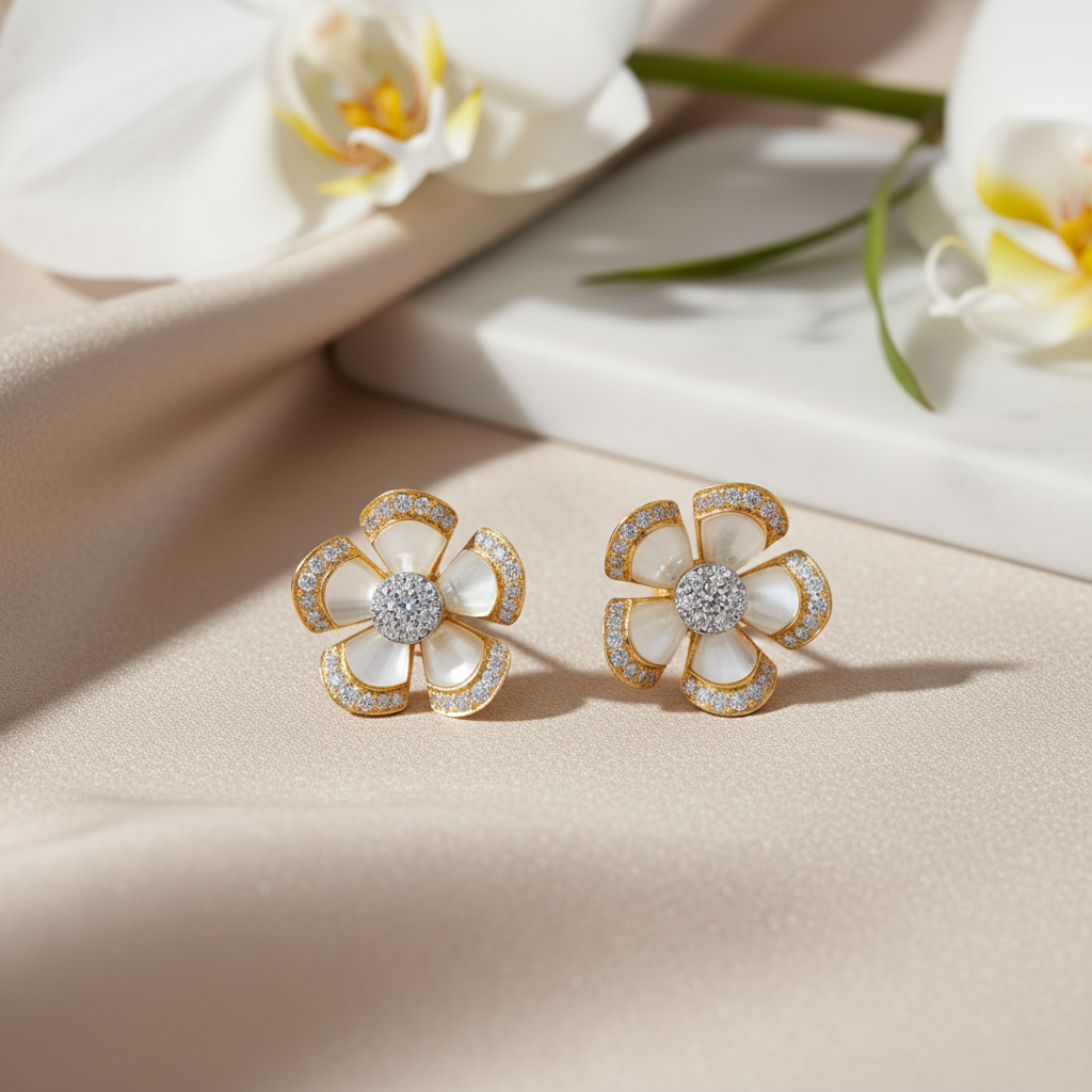 Pair of gold and white flower-shaped earrings on a white background